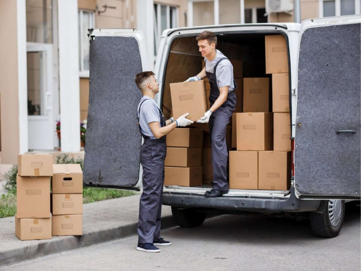 Two professional movers loading boxes into the back of a Detroit to Phoenix moving truck