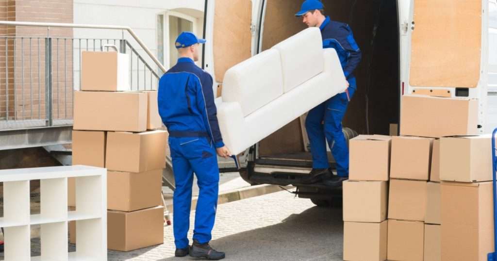 Two movers in Tempe moving a couch out of a moving truck