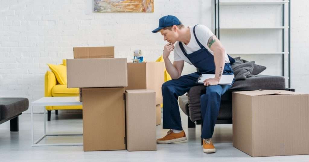 A moving professional from a moving company in Tempe looking at boxes inside a living room