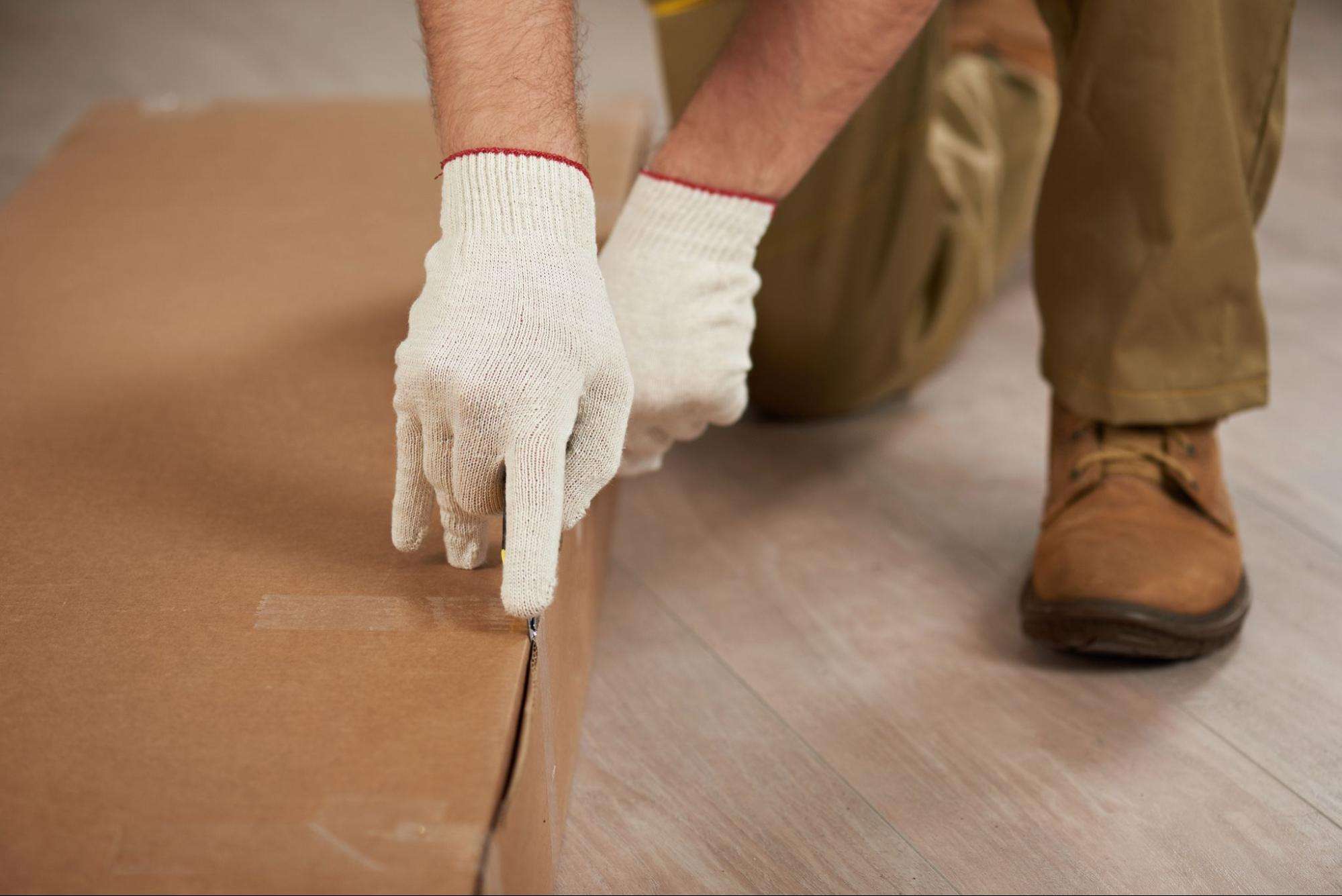 white glove delivery mover unpacking a cardboard box.