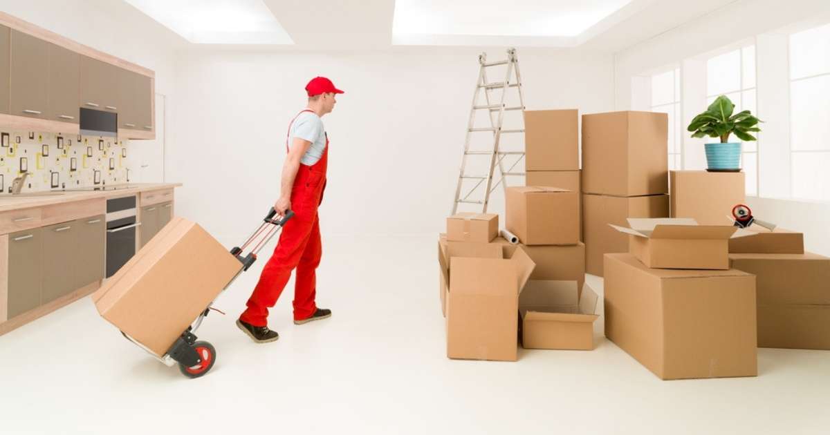A professional from a Phoenix moving company for apartments moving boxes into a room