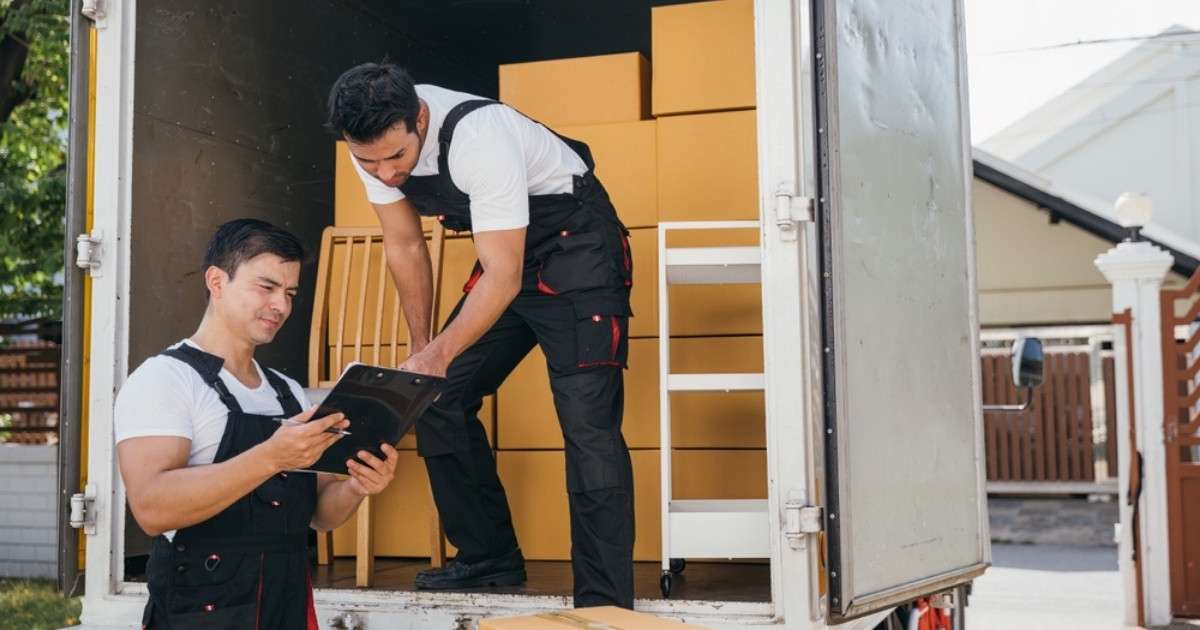 Two professionals from a Phoenix specialty moving company reviewing a checklist after packing a moving truck