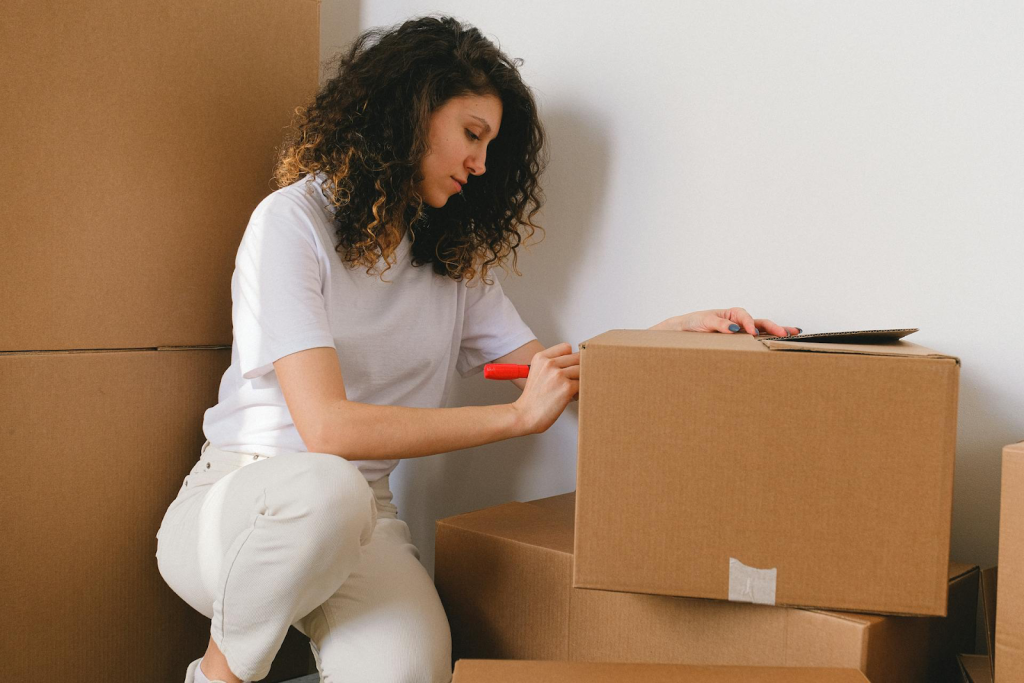 A woman marking moving boxes
