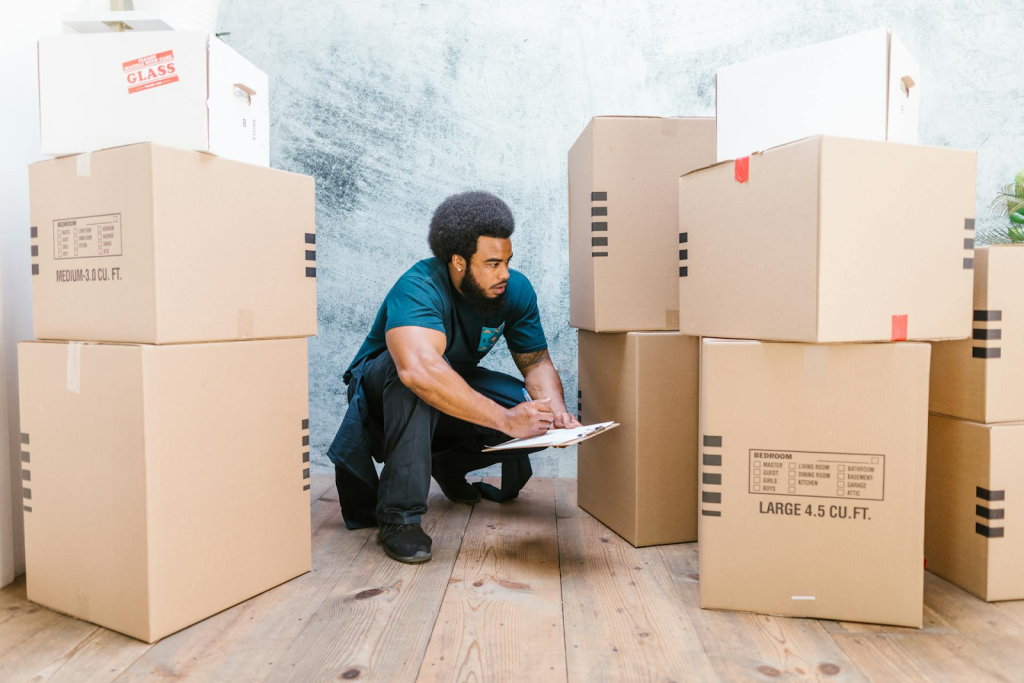 Professional mover with clipboard and boxes