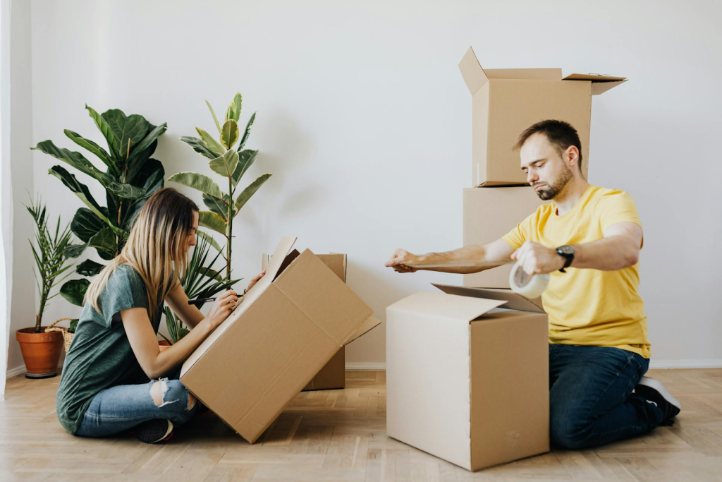 Couple marking and packing moving boxes