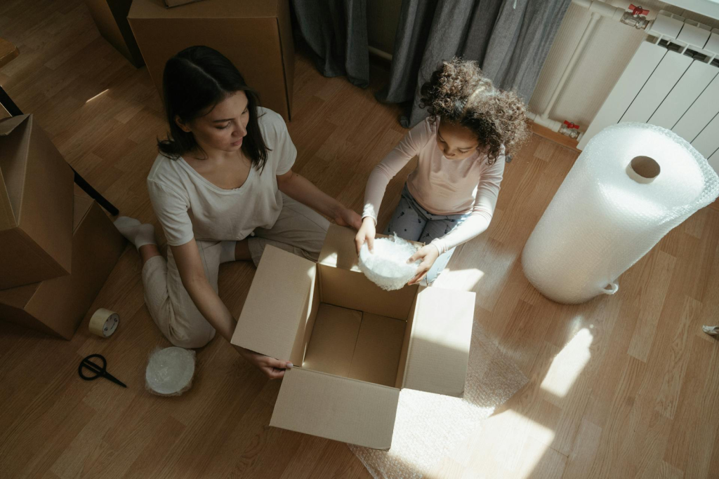 Mom and daughter using bubble wrap to pack dishes