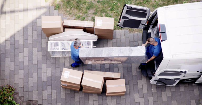 Aerial view of two movers carrying furniture out of a moving van.